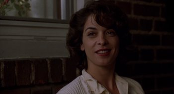 Movie still from “Romeo Is Bleeding” (1993), directed by Peter Medak – A person smiling for the camera; Close Up shot, Low angle
