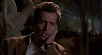 Movie still from “Romeo Is Bleeding” (1993), directed by Peter Medak – A person wearing a suit smoking a cigarette; Close Up shot, Low angle
