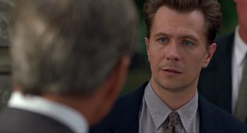 Movie still from “Romeo Is Bleeding” (1993), directed by Peter Medak – A man wearing a suit and tie talking to another man wearing a suit and tie; Close Up shot, Over the shoulder angle