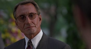 Movie still from “Romeo Is Bleeding” (1993), directed by Peter Medak – An older man wearing a suit and tie; Close Up shot, Low angle