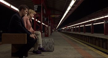 Movie still from “Romeo Is Bleeding” (1993), directed by Peter Medak – Two people sitting on a bench at a train station; Wide shot, Low angle
