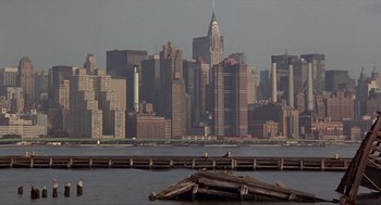 Movie still from “Romeo Is Bleeding” (1993), directed by Peter Medak – A view of a city skyline from across the water; Extreme Wide shot, High angle