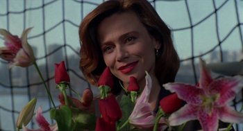 Movie still from “Romeo Is Bleeding” (1993), directed by Peter Medak – A woman with red lipstick and a bunch of red roses; Close Up shot, Low angle