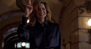 Movie still from “Romeo Is Bleeding” (1993), directed by Peter Medak – A woman in a black shirt is raising her hand; Medium shot, Low angle