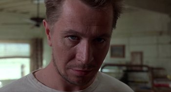 Movie still from “Romeo Is Bleeding” (1993), directed by Peter Medak – A person wearing a white t - shirt; Close Up shot, Low angle