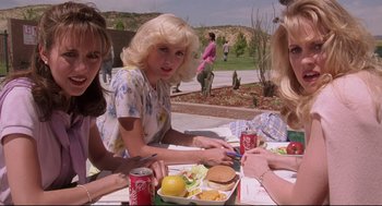 Movie still from “Romy and Michele's High School Reunion” (1997), directed by David Mirkin – A group of women sitting at a table with a plate of food; Medium shot, High angle