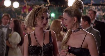 Movie still from “Romy and Michele's High School Reunion” (1997), directed by David Mirkin – Two young women are standing together and talking; Close Up shot, Over the shoulder angle