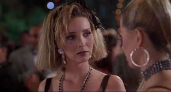 Movie still from “Romy and Michele's High School Reunion” (1997), directed by David Mirkin – A person wearing a dress and a hat; Close Up shot, Over the shoulder angle