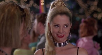 Movie still from “Romy and Michele's High School Reunion” (1997), directed by David Mirkin – A woman in a black top and a black and white necklace; Close Up shot, Over the shoulder angle