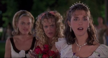 Movie still from “Romy and Michele's High School Reunion” (1997), directed by David Mirkin – A group of women standing next to each other holding roses; Close Up shot, Over the shoulder angle