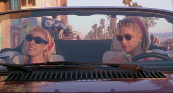 Movie still from “Romy and Michele's High School Reunion” (1997), directed by David Mirkin – Two young children in the back seat of a purple car; Medium shot, Low angle