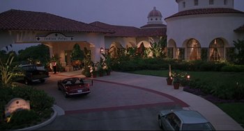 Movie still from “Romy and Michele's High School Reunion” (1997), directed by David Mirkin – A car is parked in front of a large building; Extreme Wide shot, High angle