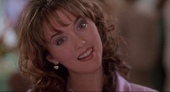 Movie still from “Romy and Michele's High School Reunion” (1997), directed by David Mirkin – A woman's face in a purple shirt; Close Up shot, Over the shoulder angle