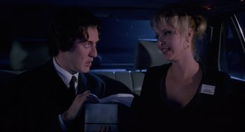 Movie still from “Romy and Michele's High School Reunion” (1997), directed by David Mirkin – A man and a woman in the back of a car; Medium shot, Low angle