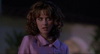 Movie still from “Romy and Michele's High School Reunion” (1997), directed by David Mirkin – A woman with curly hair wearing a pink shirt; Close Up shot, Over the shoulder angle