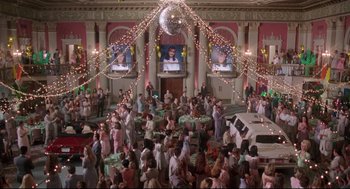Movie still from “Romy and Michele's High School Reunion” (1997), directed by David Mirkin – A crowd of people standing in a large room; Extreme Wide shot, High angle
