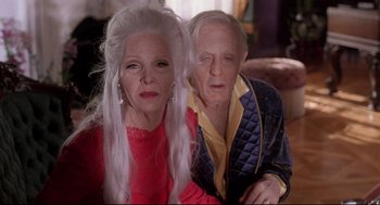 Movie still from “Romy and Michele's High School Reunion” (1997), directed by David Mirkin – An older man and a younger woman posing for a picture; Close Up shot, High angle