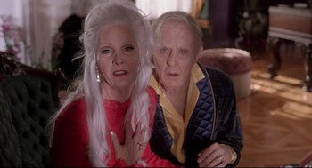Movie still from “Romy and Michele's High School Reunion” (1997), directed by David Mirkin – An older man and a younger woman posing for a picture; Medium shot, Low angle