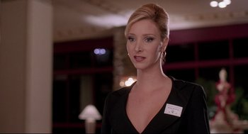 Movie still from “Romy and Michele's High School Reunion” (1997), directed by David Mirkin – A beautiful woman in a black dress and a white sign; Close Up shot, Low angle