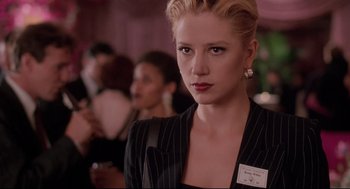 Movie still from “Romy and Michele's High School Reunion” (1997), directed by David Mirkin – A woman in a black suit with a name tag on her lapel; Close Up shot, Over the shoulder angle