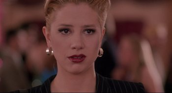 Movie still from “Romy and Michele's High School Reunion” (1997), directed by David Mirkin – A person wearing a suit and earrings; Close Up shot, Over the shoulder angle