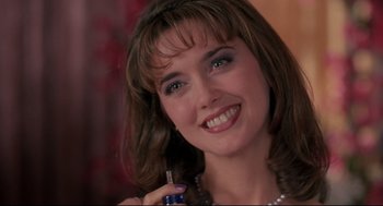 Movie still from “Romy and Michele's High School Reunion” (1997), directed by David Mirkin – A beautiful woman holding a small bottle in her hand; Close Up shot, Over the shoulder angle
