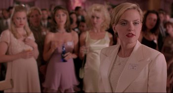 Movie still from “Romy and Michele's High School Reunion” (1997), directed by David Mirkin – A group of women standing next to each other in a room; Medium shot, Over the shoulder angle