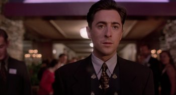 Movie still from “Romy and Michele's High School Reunion” (1997), directed by David Mirkin – A person wearing a suit and tie; Close Up shot, Low angle