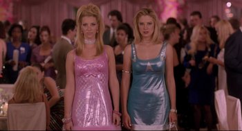 Movie still from “Romy and Michele's High School Reunion” (1997), directed by David Mirkin – A couple of women standing next to each other in dresses; Medium shot, Low angle