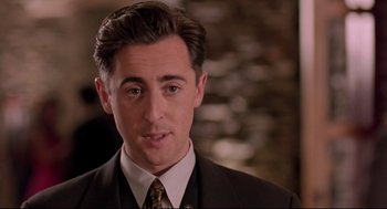 Movie still from “Romy and Michele's High School Reunion” (1997), directed by David Mirkin – A person wearing a suit and tie; Close Up shot, Over the shoulder angle