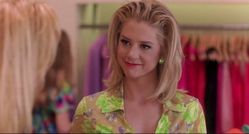 Movie still from “Romy and Michele's High School Reunion” (1997), directed by David Mirkin – A beautiful young lady with blonde hair wearing a green floral shirt; Close Up shot, Over the shoulder angle