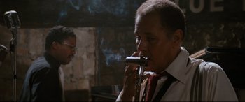 Movie still from “'Round Midnight” (1986), directed by Bertrand Tavernier – An older man smoking a pipe in front of a brick wall; Close Up shot, Low angle