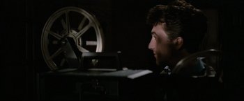 Movie still from “'Round Midnight” (1986), directed by Bertrand Tavernier – A man sitting in front of an old movie projector; Close Up shot, Low angle