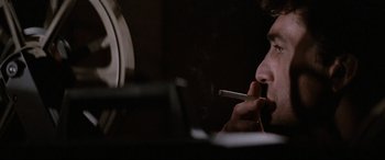Movie still from “'Round Midnight” (1986), directed by Bertrand Tavernier – A man is smoking a cigarette in a dark room; Close Up shot, Low angle