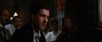 Movie still from “'Round Midnight” (1986), directed by Bertrand Tavernier – A group of people sitting in a room; Close Up shot, Over the shoulder angle