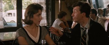 Movie still from “'Round Midnight” (1986), directed by Bertrand Tavernier – A man and a woman sitting at a table talking to each other; Medium shot, Over the shoulder angle