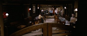 Movie still from “'Round Midnight” (1986), directed by Bertrand Tavernier – A group of people sitting in a room with musical instruments; Extreme Wide shot, High angle