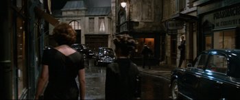 Movie still from “'Round Midnight” (1986), directed by Bertrand Tavernier – A woman and a child walking down a street; Wide shot, Over the shoulder angle