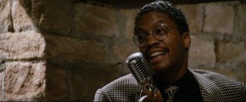 Movie still from “'Round Midnight” (1986), directed by Bertrand Tavernier – A man with a microphone in his hand; Close Up shot, High angle