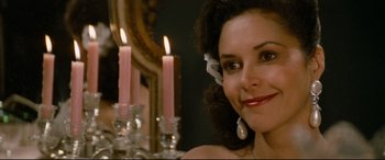 Movie still from “'Round Midnight” (1986), directed by Bertrand Tavernier – A beautiful woman sitting in front of candles; Close Up shot, Over the shoulder angle
