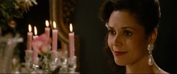 Movie still from “'Round Midnight” (1986), directed by Bertrand Tavernier – A woman sitting in front of a table with lit candles; Close Up shot, Over the shoulder angle