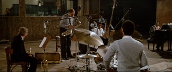 Movie still from “'Round Midnight” (1986), directed by Bertrand Tavernier – A group of men playing musical instruments in a recording studio; Extreme Wide shot, High angle