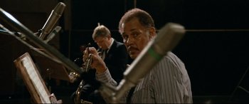 Movie still from “'Round Midnight” (1986), directed by Bertrand Tavernier – A man holding a trumpet in front of another man in a suit; Close Up shot, Over the shoulder angle