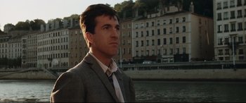 Movie still from “'Round Midnight” (1986), directed by Bertrand Tavernier – A man standing in front of a river and buildings; Close Up shot, Low angle