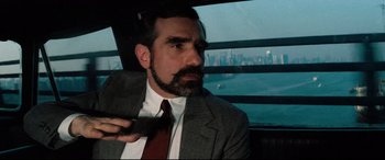 Movie still from “'Round Midnight” (1986), directed by Bertrand Tavernier – A man in a suit and tie holding a cell phone; Close Up shot, Over the shoulder angle