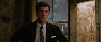 Movie still from “'Round Midnight” (1986), directed by Bertrand Tavernier – A man wearing a suit and tie standing in front of a window; Close Up shot, Low angle