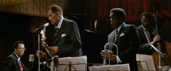 Movie still from “'Round Midnight” (1986), directed by Bertrand Tavernier – Two men in suits and ties are playing musical instruments; Medium shot, Low angle
