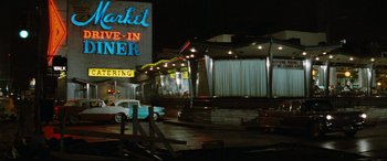 Movie still from “'Round Midnight” (1986), directed by Bertrand Tavernier – A car parked on the side of the road next to a building; Extreme Wide shot, Low angle