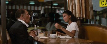 Movie still from “'Round Midnight” (1986), directed by Bertrand Tavernier – A woman sitting at a table in front of a man; Medium shot, Over the shoulder angle