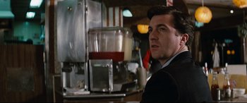 Movie still from “'Round Midnight” (1986), directed by Bertrand Tavernier – A man sitting in front of a coffee maker; Close Up shot, Over the shoulder angle